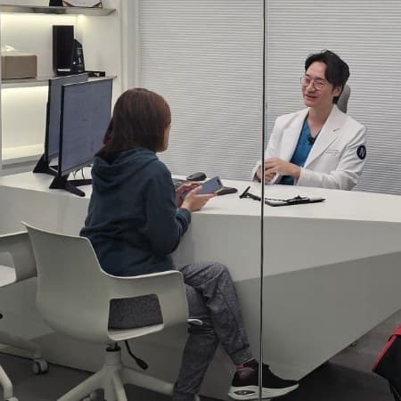 상담실에서 보호자와 이야기하는 수의사